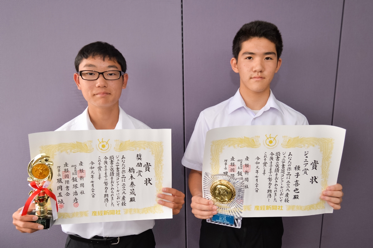 賞状を手に笑顔を見せる種子喜也さん(右)と橋本泰晟さん