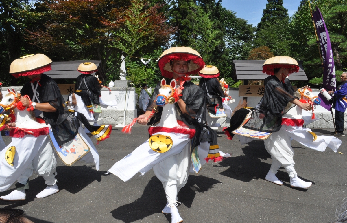 三婆羅塚の前で間明田駒踊りを奉納する同踊り保存会のメンバー