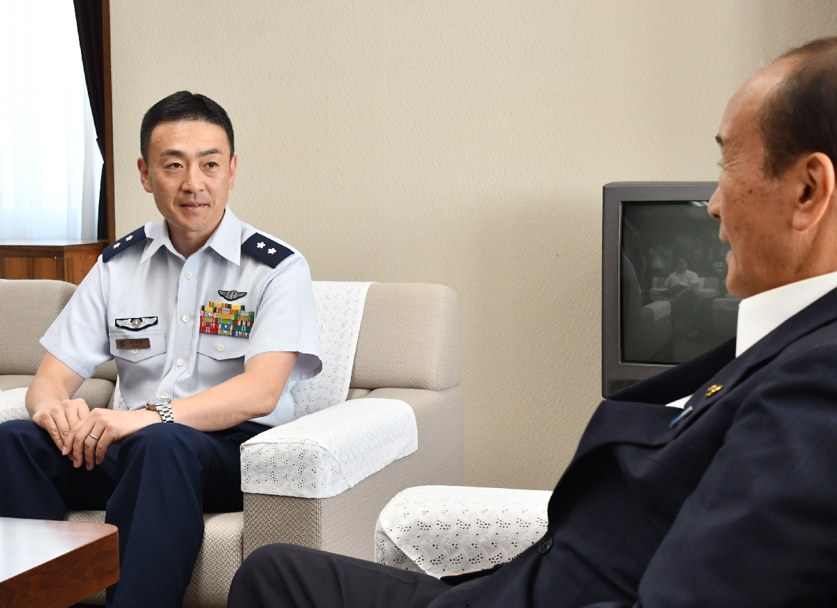 夜間飛行再開の方針を伝えるため小桧山吉紀市長(右)と面会する久保田隆裕司令=10日、三沢市役所