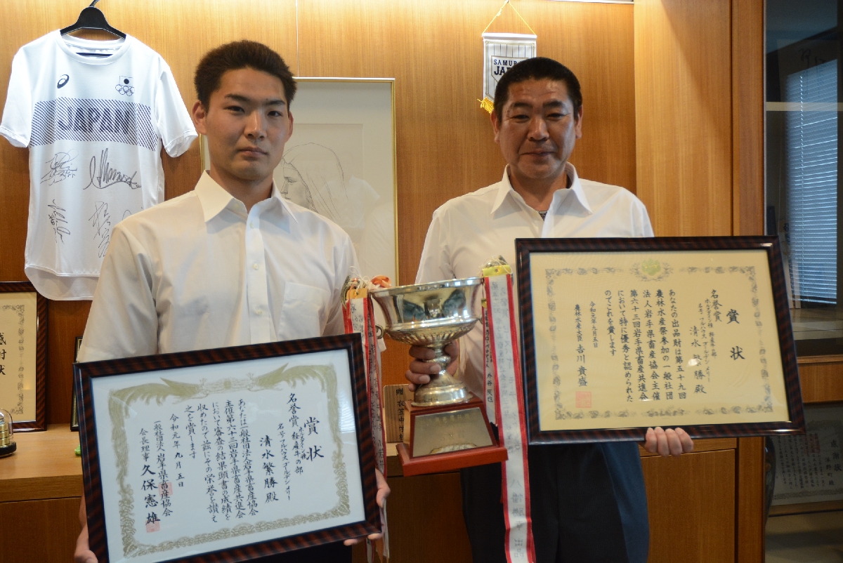 経産牛の部で最高位の名誉賞を受賞した清水繁勝さん(右)と長男の利月さん