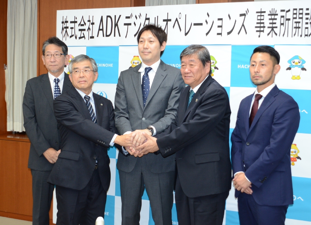 小林眞市長(右から2人目)や田中泰宏部長(左から2人目)と握手する掛谷章往社長(中央)=8日、八戸市庁