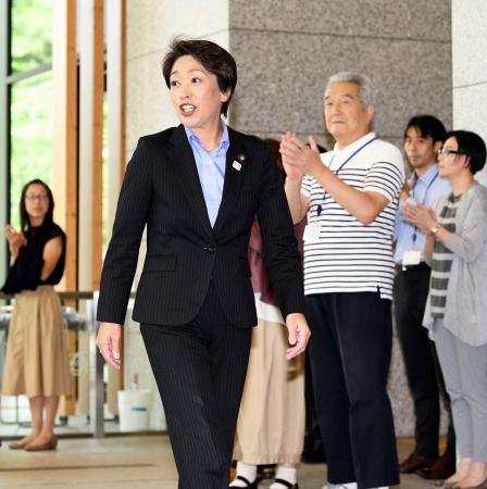 職員らの出迎えを受けて初登庁する橋本五輪相=12日午前、内閣府