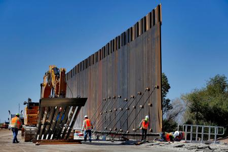 米西部アリゾナ州ユマでメキシコ国境沿いにフェンスを設置する業者=10日(AP=共同)