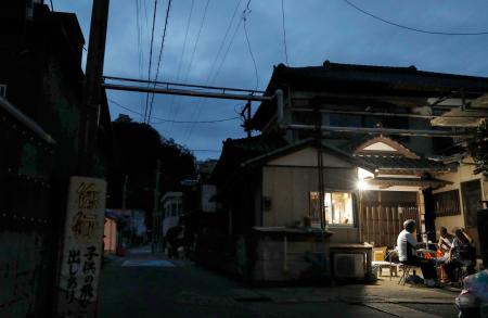 停電が続く千葉県鋸南町では、住民らが工面したガソリンと発電機でともした明かりに人々が集まっていた=12日夕