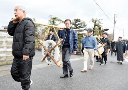 大きな鏡餅を寺まで運ぶ男性ら=9日、鳥取県境港市