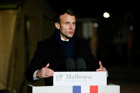 フランス東部ミュルーズに設置された野外病院を訪問後、演説するマクロン大統領=25日(ロイター=共同)