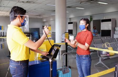 離れた位置から搭乗券を読み取る方法を紹介するセブ・パシフィック航空のスタッフ(同社提供)
