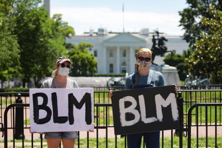 30日、米ホワイトハウス前で、黒人男性の暴行死に抗議する人々=ワシントン(ゲッティ=共同)