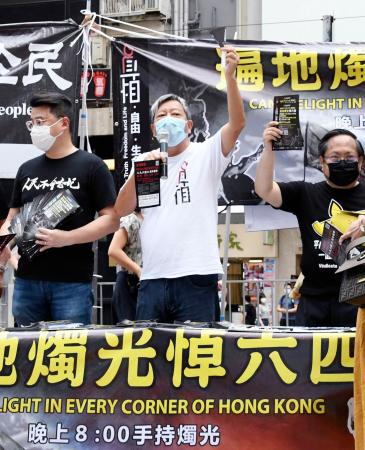 繁華街コーズウェイベイで、市民に向け演説する民主派団体の幹部ら=31日、香港(共同)