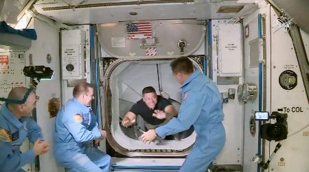 米スペースXの宇宙船クルードラゴンで国際宇宙ステーションに到着したNASAのロバート・ベンケン飛行士(奥)。他の3人は先に滞在中のNASAとロシアの飛行士(NASAテレビ)