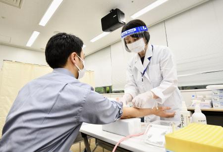 調査開始に先立ち、公開された新型コロナウイルスの大規模抗体調査のデモンストレーション=1日午前、東京都板橋区