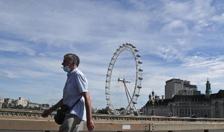 ロンドン市内を歩くマスク姿の男性=5月26日(AP=共同)