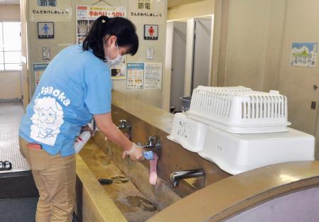 学校施設の消毒作業をする教諭=2日午後、北九州市