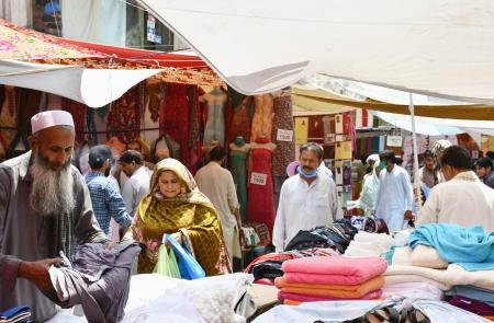 25日、マスクを着けずに買い物する人たち=イスラマバード近郊ラワルピンディ(共同)