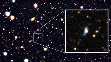 新たに発見された、誕生して1千万年ほどしかたっていないとみられる銀河(拡大部分中央の白い天体)(国立天文台など提供)