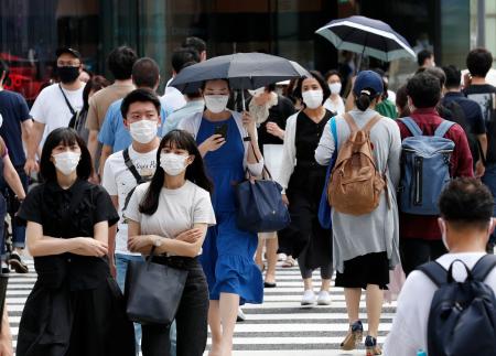 東京・銀座で日傘を差して歩くマスク姿の人ら=1日午後