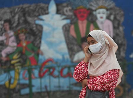 マスク姿で電話をする女性=7月20日、インドネシア・ジャカルタ(AP=共同)